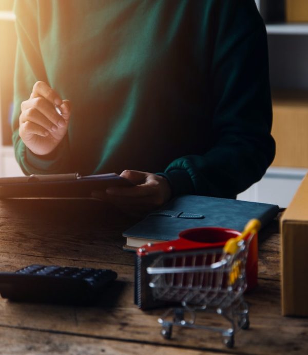 Startup SME small business entrepreneur of freelance Asian woman wearing apron using laptop and box to receive and review orders online to prepare to pack sell to customers, online sme business ideas.